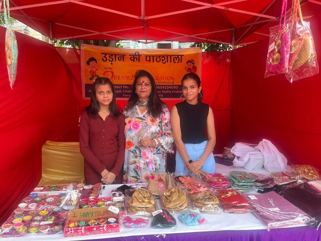 Girls running their Durga Pooja stall with potlis and thal covers